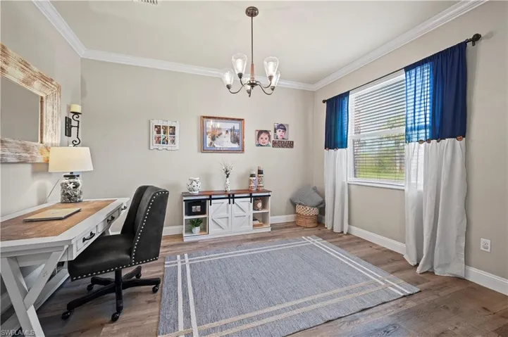 Office with an inviting chandelier, crown molding, and hardwood / wood-style floors