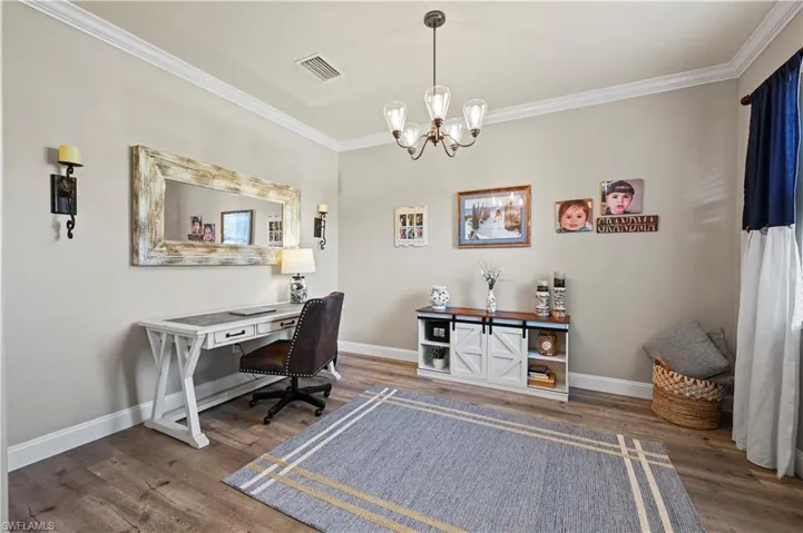 Office space featuring ornamental molding, dark hardwood / wood-style flooring, and a notable chandelier