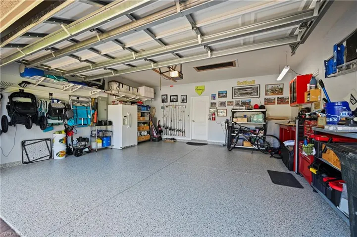 Garage featuring a garage door opener and white refrigerator with ice dispenser
