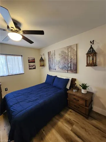 Bedroom featuring wood finished floors, a ceiling fan, and baseboards