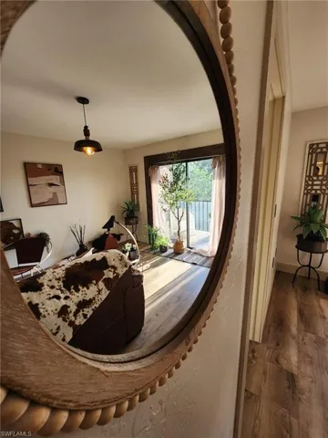 Foyer entrance with arched walkways, dark wood finished floors, and baseboards