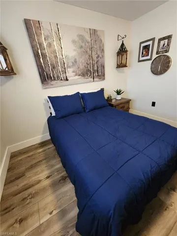 Bedroom featuring baseboards and wood finished floors