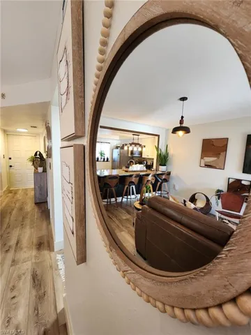 Living room featuring arched walkways, light wood finished floors, and baseboards