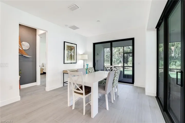 Dining area featuring light wood-finish flooring, white baseboards, and bright white walls