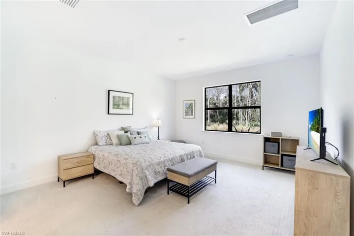 Spacious room with plush carpeting, a large picture window, and white walls