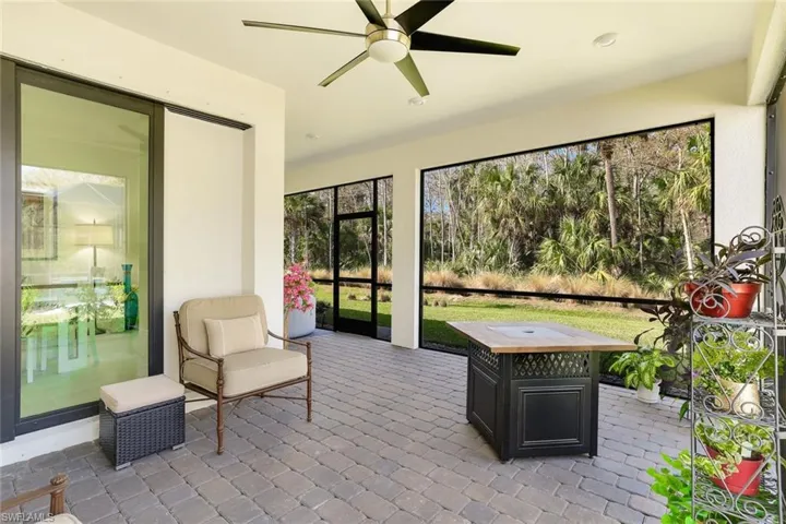 Screened outdoor living area featuring paver flooring, a ceiling fan, recessed lighting, and a sliding glass door entry to the interior
