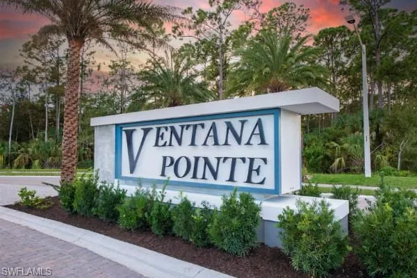 Community entrance sign featuring integrated lighting, a stone-textured base, and a prominent display of the community name