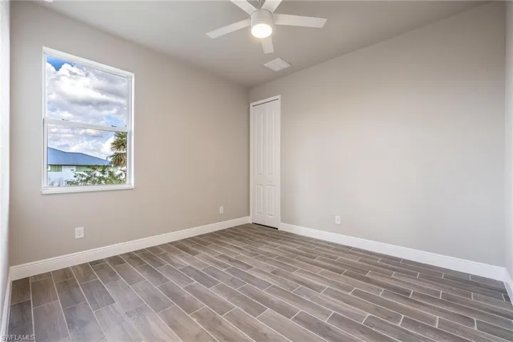 Empty room with wood finish floors and a ceiling fan-Finishes may vary