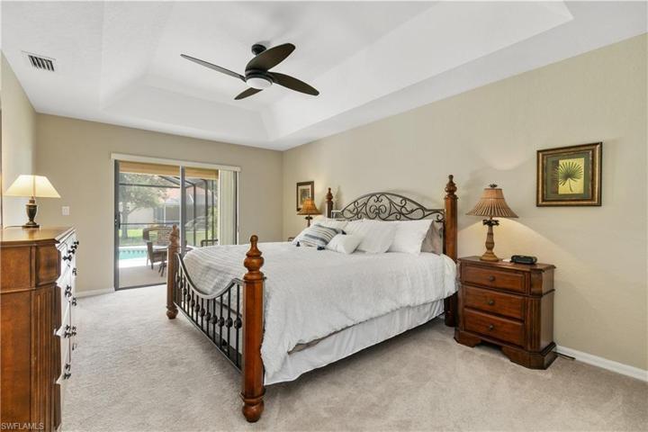 Primary bedroom overlooks lanai and pool