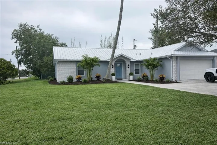 Ranch-style home with brick siding, a garage, and a front lawn