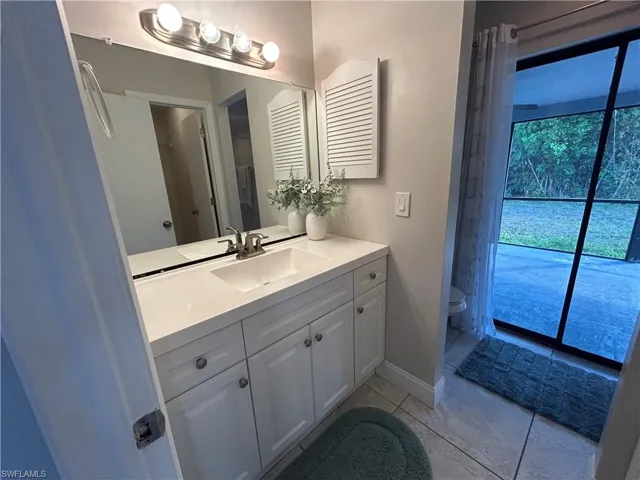 Full bathroom with vanity and light tile patterned flooring