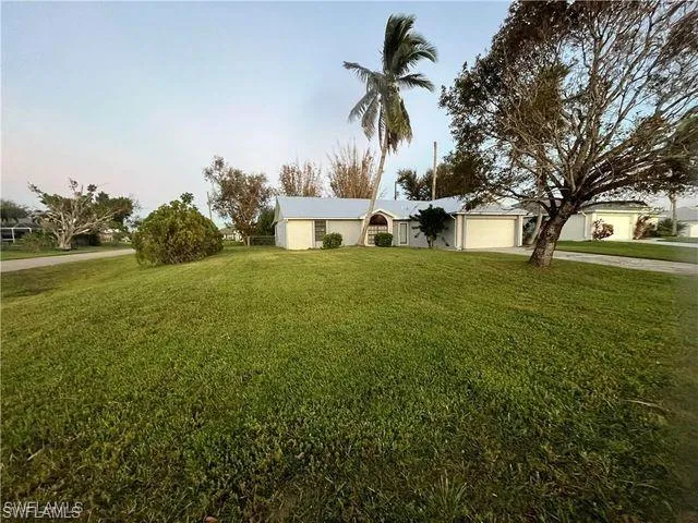 View of front facade with a front lawn, concrete driveway, and a garage