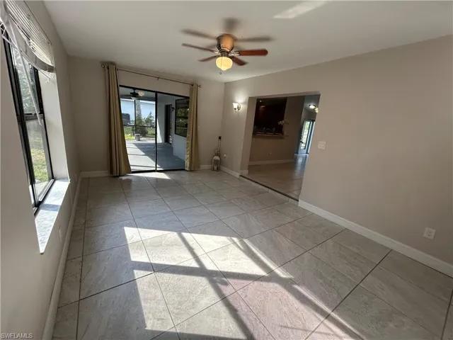 Unfurnished room with ceiling fan and light tile patterned floors