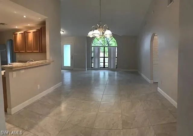 Unfurnished dining area with a chandelier, recessed lighting, and light tile patterned floors