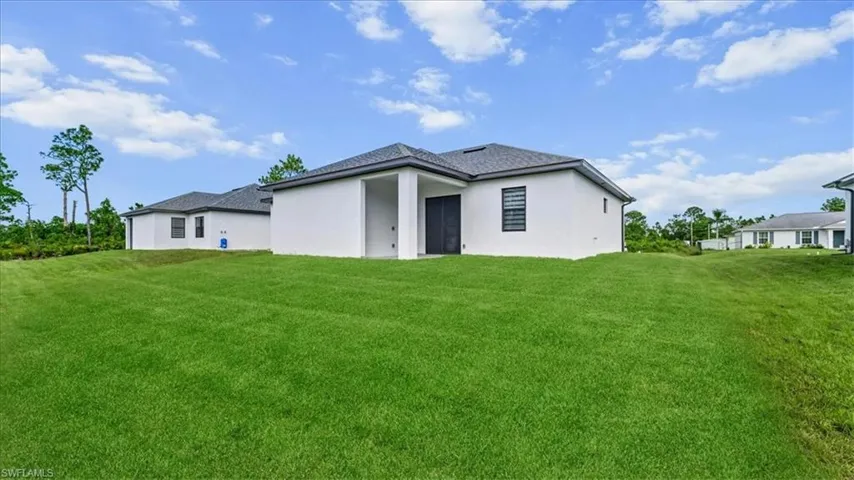 Back of property with a lawn, stucco siding, and a patio