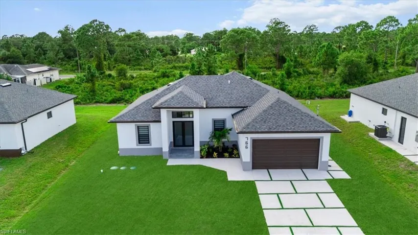 View of front of property featuring a front yard, stucco siding, and an attached garage