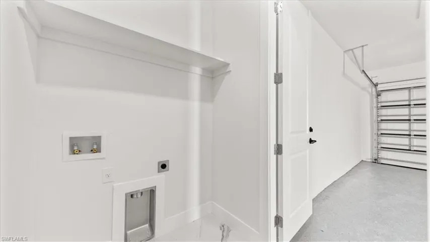 Laundry room with hookup for an electric dryer, washer hookup, and a garage