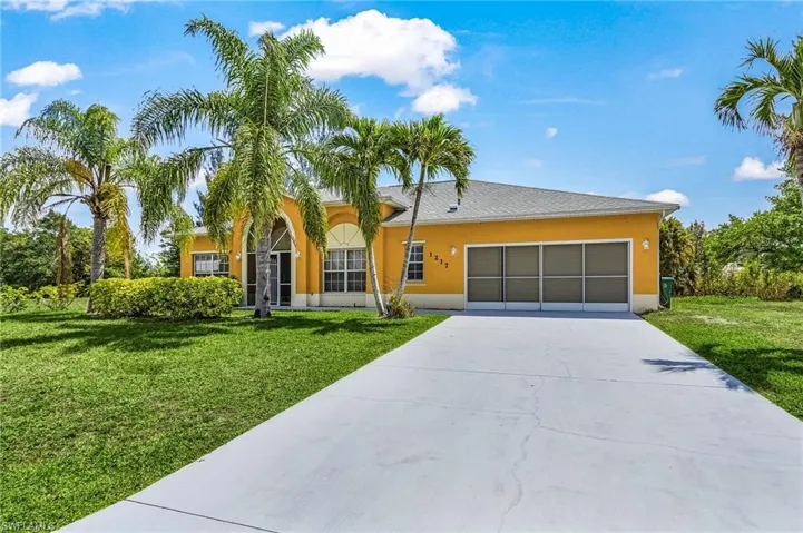 Impressive curb presence featuring a wide driveway, elegant arched entry, and sun-filled exterior.