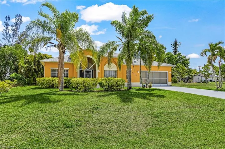 Beautifully maintained home with tropical landscaping, mature palm trees, and inviting curb appeal.