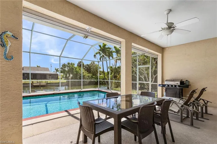 Screened lanai overlooking the pool and canal, offering the perfect setting for outdoor dining, relaxing, and entertaining.