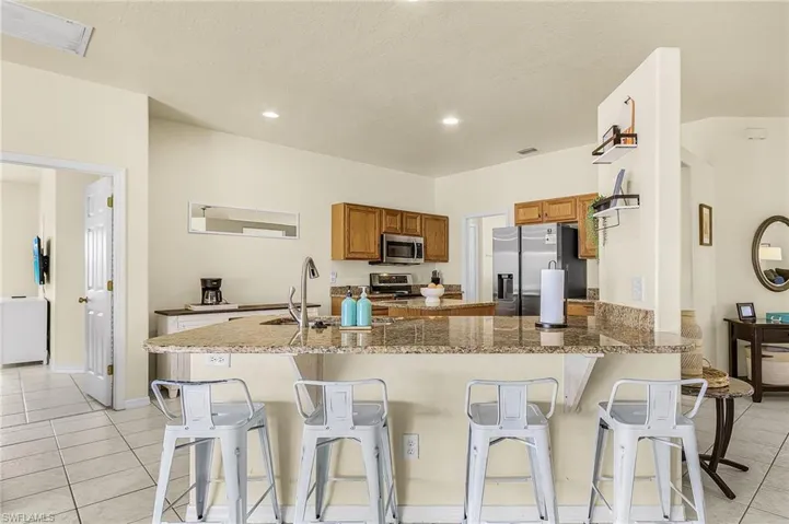 Spacious kitchen with oversized center island, granite countertops, and ample seating, perfect for gathering and entertaining