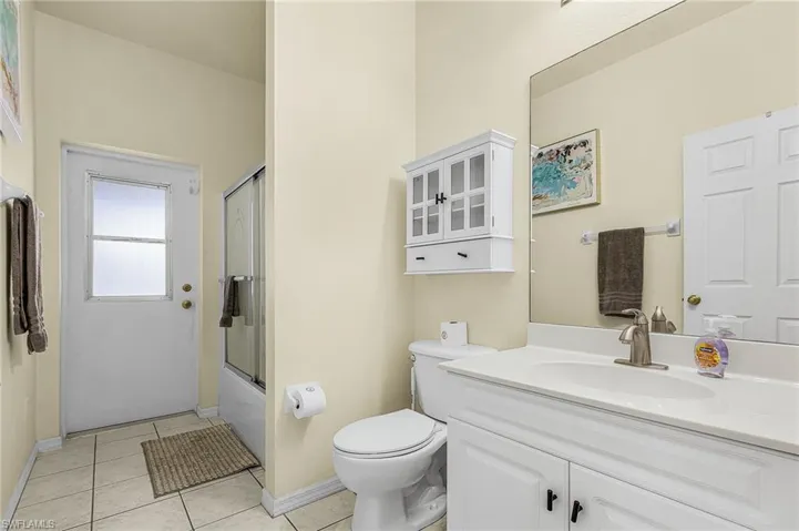 Well-appointed full bathroom featuring a tub/shower combination and direct access to the pool and lanai
