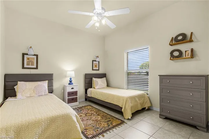 Spacious secondary bedroom with natural light and room for multiple beds—ideal for guests, family, or shared living.