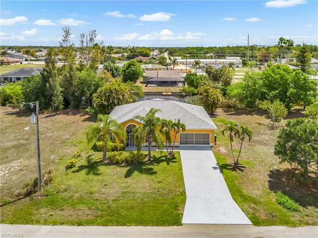 Aerial view showcasing the spacious lot, surrounding greenery, and prime positioning.
