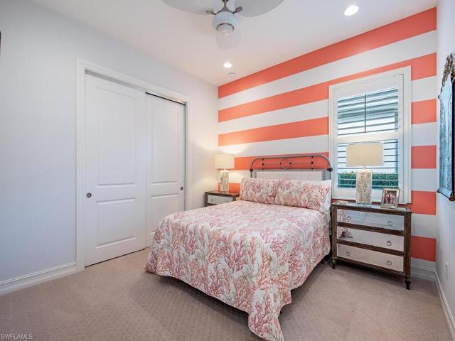 Comfortable guest bedroom includes custom closets shelving