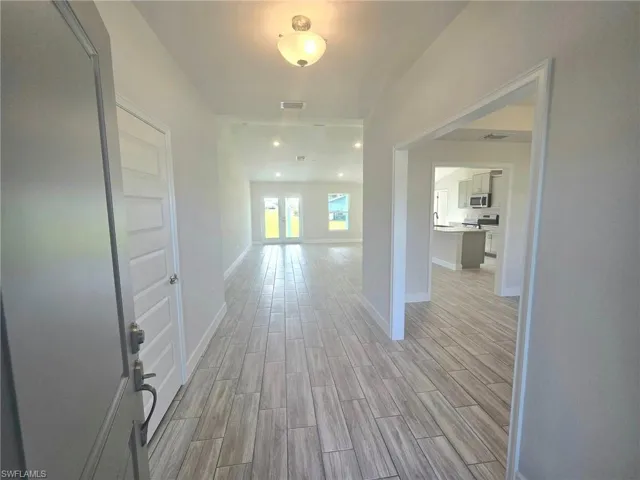 Corridor with light hardwood / wood-style floors and french doors
