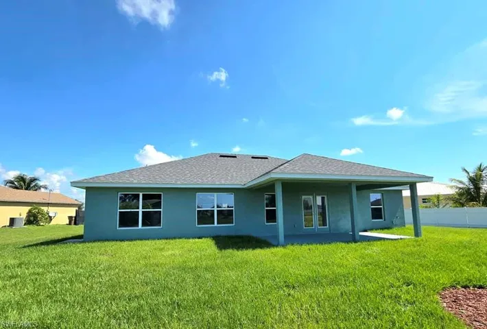Rear view of house featuring a lawn