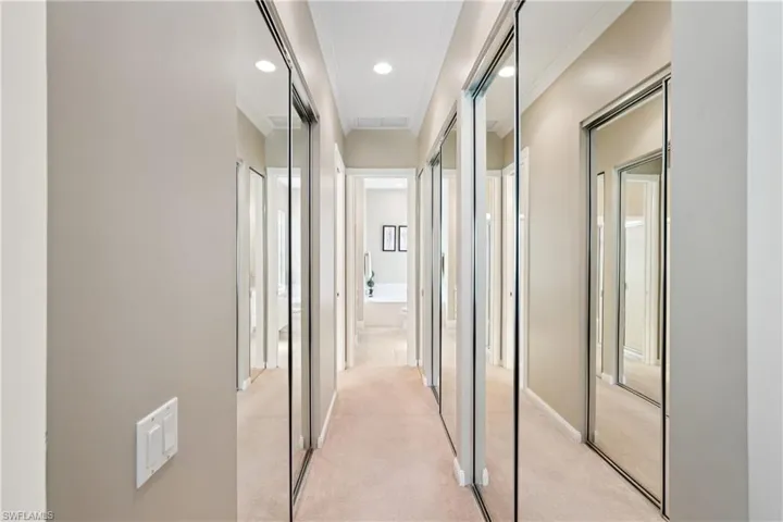 Hallway with light colored carpet, ornamental molding, and recessed lighting