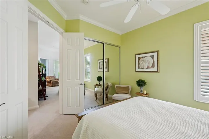 Bedroom with ornamental molding, carpet flooring, a closet, and a ceiling fan