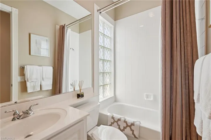 Full bath with shower / tub combo with curtain and vanity