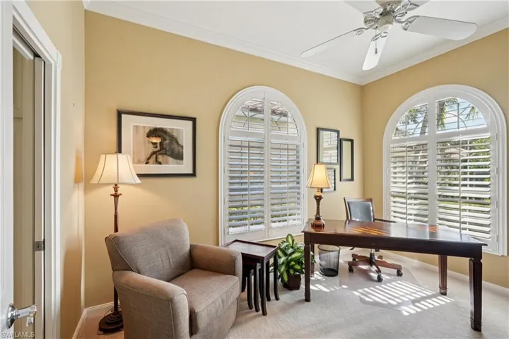Carpeted office featuring ornamental molding and ceiling fan