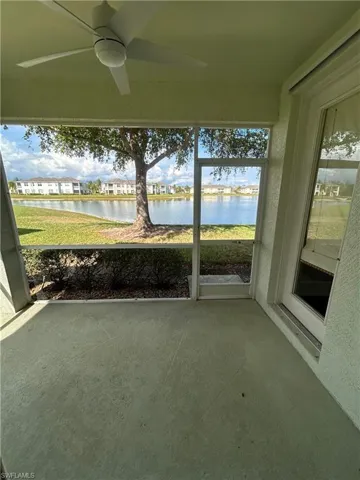 Unfurnished sunroom with a ceiling fan, a water view, and plenty of natural light
