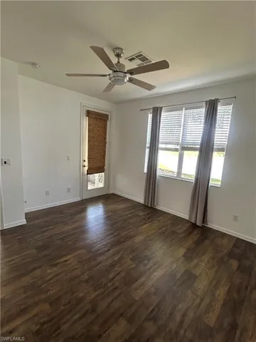 Empty room featuring dark wood-style floors and a ceiling fan