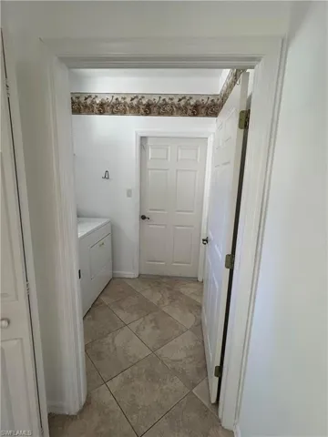 Bathroom with light tile patterned floors and washing machine and clothes dryer