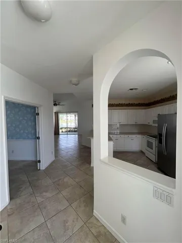 Hall with light tile patterned floors and lofted ceiling