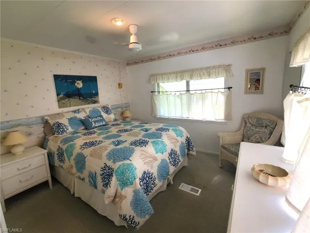Primary bedroom with neutral carpet and ceiling fan.