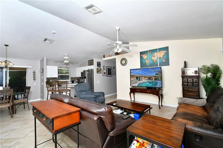 The open-concept living area features light-colored walls and tiled flooring