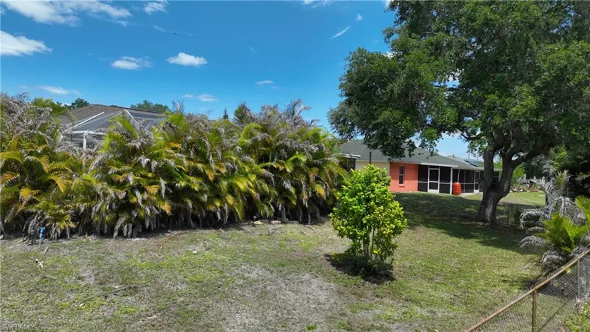 The property features an extensive lawn area with mature trees and vibrant green foliage