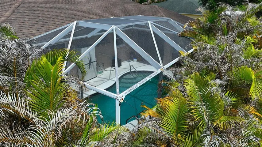 The property features an outdoor swimming pool enclosed by a screened cage structure