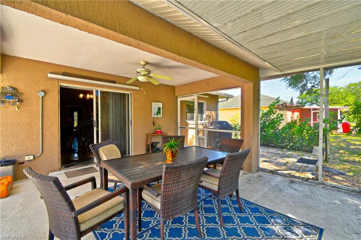 The screened-in patio features a ceiling fan, concrete flooring, and a sliding glass door leading to the interior