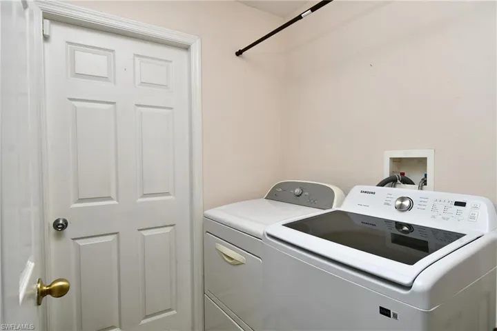 Dedicated laundry area featuring a white paneled door and light-colored walls