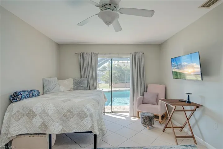 Bedroom with access to outside, light tile patterned flooring, and ceiling fan