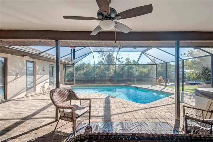 Swimming pool featuring a lanai, a patio, and a sunroom