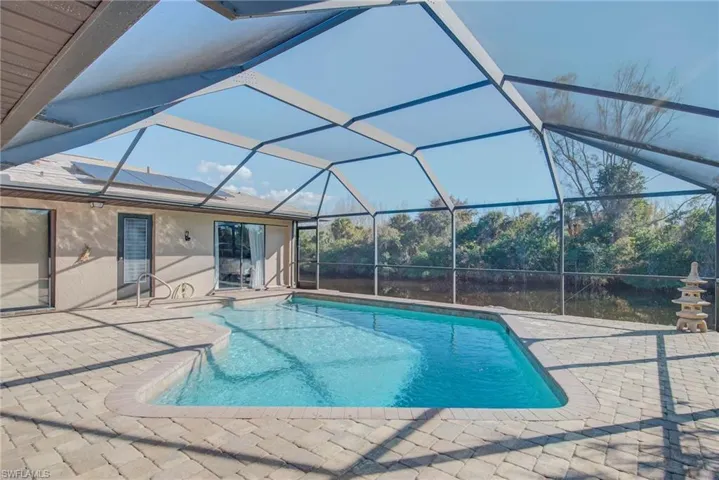 Outdoor pool with a lanai, a sunroom, and a patio area