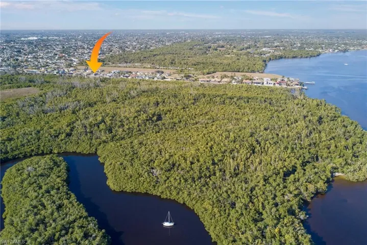 Aerial overview of property's location featuring a large body of water and a heavily wooded area