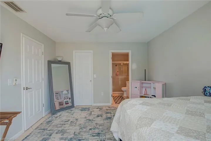Bedroom featuring ceiling fan and ensuite bathroom